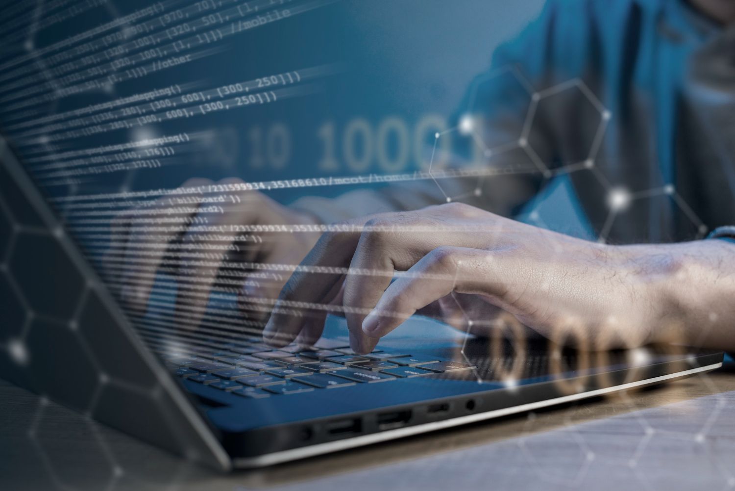 Stock photo of hands typing on a laptop keyboard with an overlay of binary code and network graphics, symbolizing software prototyping