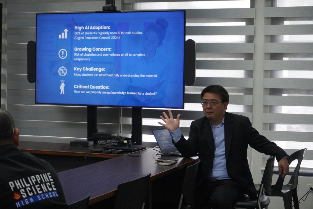 A presenter gestures in front of a slide listing AI adoption stats: 86% of students regularly use AI (Digital Education Council, 2024), plus points on plagiarism risk, students not understanding material, and the question of how to properly assess student knowledge