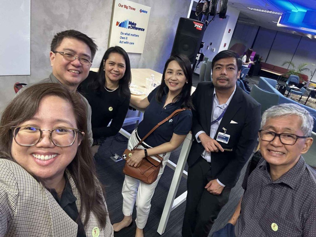 Selfie of six people, including PSI's Allan Tan, with the AAP Board of Trustees and fellow members in an office lounge area